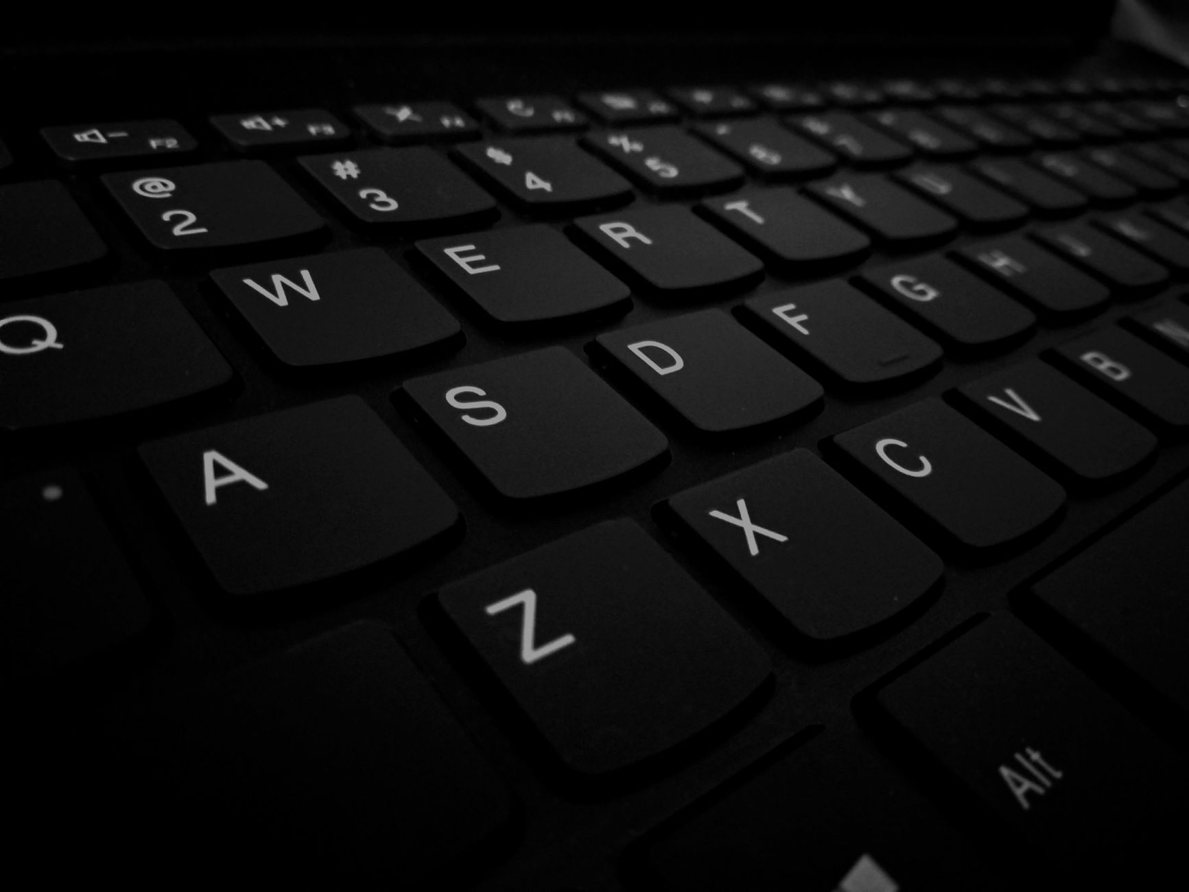 Dramatische close-up van een zwart computertoetsenbord met details van de toetsen.